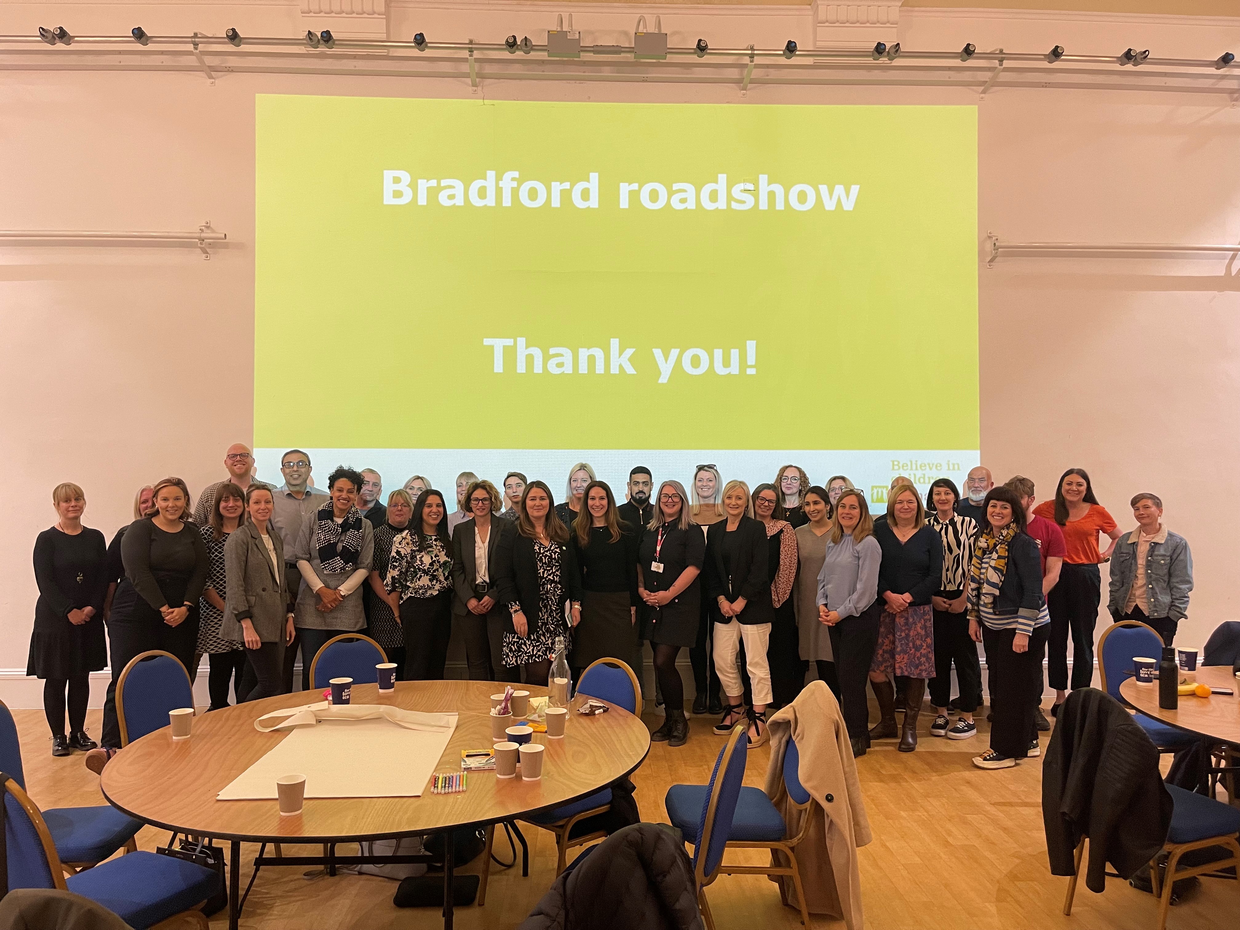 a group of about 40 people pose in front of a slide reading 'Bradford Roadshow. Thank you'
